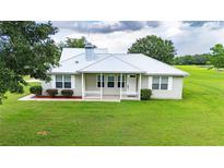 Charming single-story home featuring a well-manicured lawn and a classic white picket fence at 39905 Townsend Rd, Dade City, FL 33525