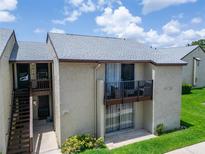 Condo exterior showcasing a balcony, neutral stucco, and well-maintained landscaping adding curb appeal at 4215 E Bay Dr # 1801E, Clearwater, FL 33764
