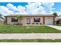 Charming single-story home with stone accents, well-maintained lawn, and a delightful palm tree at 630 Kirkland Cir, Dunedin, FL 34698