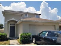 Charming two-story home featuring an attached garage and lush green bushes at the front at 1015 Windton Oak Dr, Ruskin, FL 33570