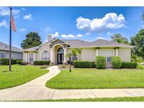 Well-manicured front yard with a lush green lawn and elegant landscaping creating a welcoming entrance at 1208 Carriage Park Dr, Valrico, FL 33594