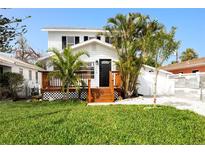 Charming two-story home featuring a front yard and beautiful tropical landscaping around the entrance at 13148 3Rd E St, Madeira Beach, FL 33708