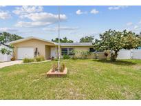 Charming single-story home featuring a well-maintained lawn and mature landscaping at 1707 Cardinal Dr, Clearwater, FL 33759