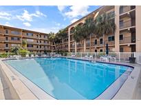Swimming pool featuring several chair and table seating arrangements and condo building in the background at 2525 W Bay Dr # B43, Belleair Bluffs, FL 33770