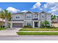 Two story home featuring neat landscaping, a two car garage, and neutral toned paint at 26972 Evergreen Chase Dr, Wesley Chapel, FL 33544