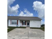 Charming single-story villa with a white exterior, red shutters, and a well-maintained front yard at 3007 Wainwright Ct, New Port Richey, FL 34655