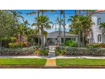 Charming single-story home with lush landscaping, palm trees, and walkway to front door at 301 23Rd Ne Ave, St Petersburg, FL 33704