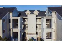 Exterior view of a light gray condominium building with multiple balconies, and a dark roof at 3127 W Sligh Ave # 303B, Tampa, FL 33614