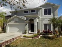 Charming two-story home with well-maintained landscaping, mature palm trees, and a two car garage at 3512 Osprey Cove Dr, Riverview, FL 33578