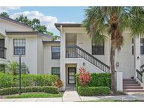 Inviting condo exterior featuring well-maintained landscaping and a classic stucco facade at 4735 Winslow Beacon # 14, Sarasota, FL 34235