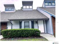 Charming condo with gray roof, white siding, and a well-maintained green hedge at 5203 Oak Charter Ct # 5203, Temple Terrace, FL 33617