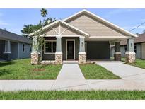 Charming single-story home with a covered porch, stone accents, and a well-manicured lawn at 5703 N 20Th St, Tampa, FL 33610
