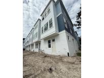 Modern townhome with white stucco and blue siding, featuring large windows and contemporary design at 6605 N Nebraska Ave # 11, Tampa, FL 33604