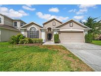 Charming single-Gathering home featuring a well-maintained lawn, neutral colors, and a two-car garage at 12510 Loquat Way, Tampa, FL 33626
