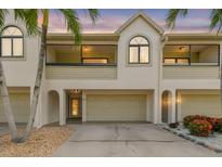 Inviting townhome with a two-car garage, lush landscaping, and a charming architectural design at 2363 Hanover Dr, Dunedin, FL 34698