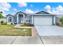 Charming single-story home with a well-manicured lawn and a two-car garage at 23917 Pow Wow Dr, Lutz, FL 33559