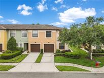 Inviting townhome featuring a two-car garage, manicured landscaping, and a charming, well-maintained exterior at 2628 Oleander Lakes Dr, Brandon, FL 33511