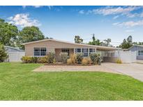 Charming home boasts a well-manicured lawn and a welcoming brick walkway, leading to a covered carport at 2861 Pinellas Point S Dr, St Petersburg, FL 33712