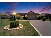 Charming single-story home featuring a well-manicured lawn, lovely landscaping, and a two-car garage at 304 Caloosa Palms Ct, Sun City Center, FL 33573