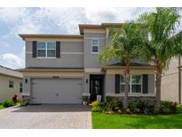 Charming two-story home with a well-manicured lawn, palm trees, and gray trim at 3144 Mountain Spruce Ter, Wesley Chapel, FL 33543