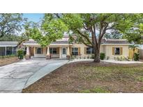 Charming single-story home featuring a mature tree, well-kept lawn, and a welcoming front porch at 4419 W El Prado Blvd, Tampa, FL 33629