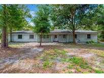 Charming single-story home featuring a light-colored brick facade and mature trees at 605 Ronele Dr, Brandon, FL 33511