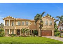 Stately two-story home with a well-manicured lawn, swaying palms, and a two-car garage at 131 Miramar Ne Blvd, St Petersburg, FL 33704