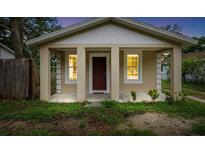 Charming home with a front porch, windows, and a striking red front door at 14935 Julian St, Dade City, FL 33523