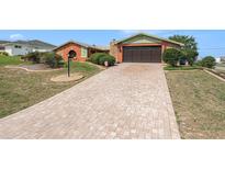 Charming single-Gathering home with brick driveway and attached garage, offering a well-maintained exterior and inviting curb appeal at 159 Canby Cir, Spring Hill, FL 34606