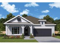 Charming home with manicured landscaping and a black garage door nestled under a blue sky with puffy clouds at 1614 Running Tide Pl, Sarasota, FL 34240