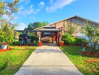 Inviting home exterior with a charming gazebo, well-manicured lawn, and convenient covered parking at 22798 Penny Loop, Land O Lakes, FL 34639