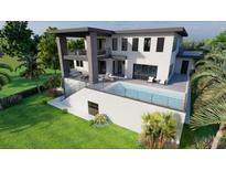 Modern home featuring a pristine pool with outdoor seating areas and spacious balconies overlooking the lush landscape at 26 Harborpointe Dr, Port Richey, FL 34668