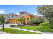 Charming single-story home featuring a well-manicured lawn, arched entryway, and a two-car garage at 3824 Duke Firth St, Land O Lakes, FL 34638