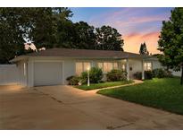 Charming single-story home with a well-maintained lawn, driveway, and attached garage at dusk at 3839 18Th N Ave, St Petersburg, FL 33713