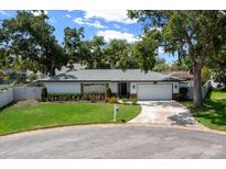 Charming single-story home featuring a manicured lawn, mature trees, and a two-car garage at 4124 Herrick Ln, Sarasota, FL 34241