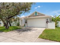 Charming single-story home featuring a well-manicured lawn and a two-car garage with wreaths at 5826 Taywood Dr, Tampa, FL 33624