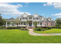 Stately two-story home with lush lawn, brick accents, covered porch, and beautiful gazebo at 8410 Kenavis Pl, Odessa, FL 33556