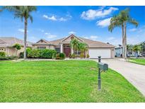 Charming single-story home featuring a lush green lawn, palm trees, and a welcoming front entrance at 8521 30Th E St, Parrish, FL 34219