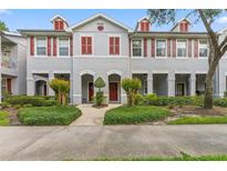 Charming townhome with manicured landscaping, red shutters, and inviting front entrances at 9418 W Park Village Dr # 105, Tampa, FL 33626
