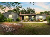 Charming single-story home with well-maintained lawn, mature trees, and inviting front porch at 9602 N Rome Ave, Tampa, FL 33612