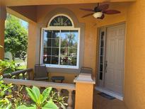 Charming front porch features neutral colors, a ceiling fan, and a sunny window at 1855 Briland St, Tarpon Springs, FL 34689