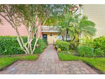 Inviting condo exterior with lush landscaping and a charming brick walkway leading to the entrance at 2424 W Tampa Bay Blvd # G204, Tampa, FL 33607