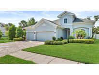 Charming single-Gathering home featuring a well-manicured lawn, 3 car garage, and lush landscaping at 26 Concord Dr, Dunedin, FL 34698