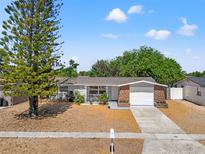Charming single-story home with well-maintained landscaping, light grey exterior and a one car garage at 4922 Bola St, New Port Richey, FL 34652