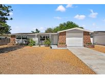 Charming single-story home with a stone accent, front lawn, and attached garage at 4922 Bola St, New Port Richey, FL 34652