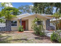 Charming single-story home featuring a red door, stone accents, and well-maintained front yard at 5611 Burlington N Ave, St Petersburg, FL 33710