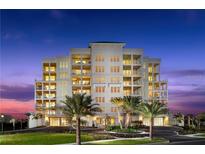 Stunning multi-story condominium with manicured lawn and palm tree landscaping, showcasing luxury coastal living at twilight at 125 Belleview Boulevard # 203, Belleair, FL 33756