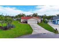 Charming single-story home featuring a red tile roof, well-manicured lawn, and a long driveway leading to a two-car garage at 1414 75Th Nw St, Bradenton, FL 34209