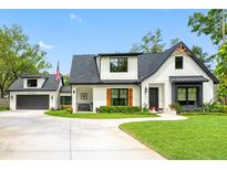 Charming two-story home with a modern farmhouse style, landscaped front yard, and separate garage at 18202 Abbey Ln, Lutz, FL 33548