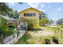 Charming two-story home with a sunny yellow exterior, featuring a quaint porch and simple landscaping at 214 W Hanna Ave # A, Tampa, FL 33604